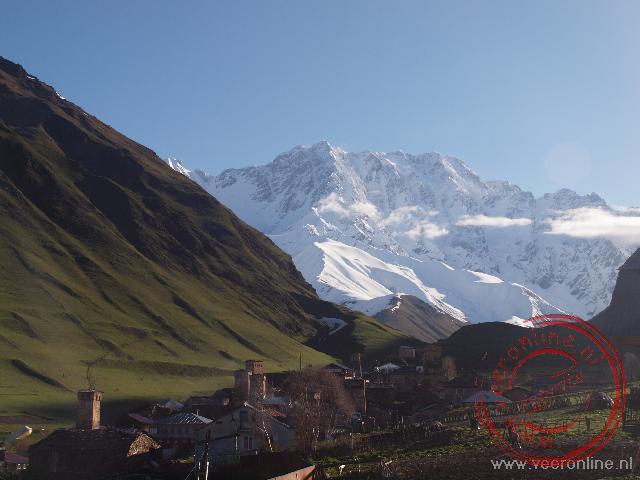 het bergdorp Ushguli ligt prachtig tegen de besneeuwde bergtoppen