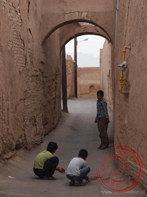 Kinderen knikkeren in de straatjes van Yazd
